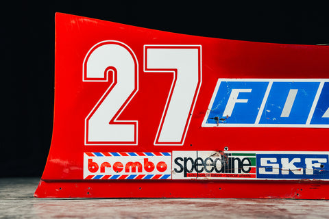 Close-up of Ferrari 126CK side wing with classic FIAT and Ferrari logos, tribute to Villeneuve. / Dettaglio dell'ala laterale Ferrari 126CK con loghi FIAT e Ferrari, tributo a Villeneuve.