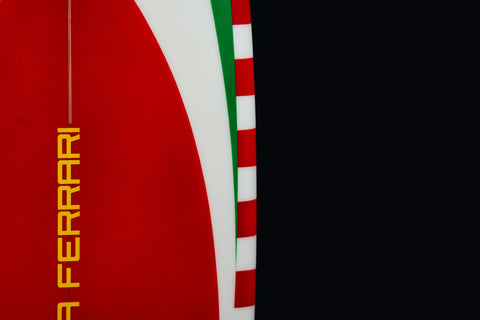 Side view of the Ferrari Limited Edition surfboard with red and white striped borders. / Vista laterale della tavola da surf Ferrari in edizione limitata con bordi a strisce rosse e bianche.