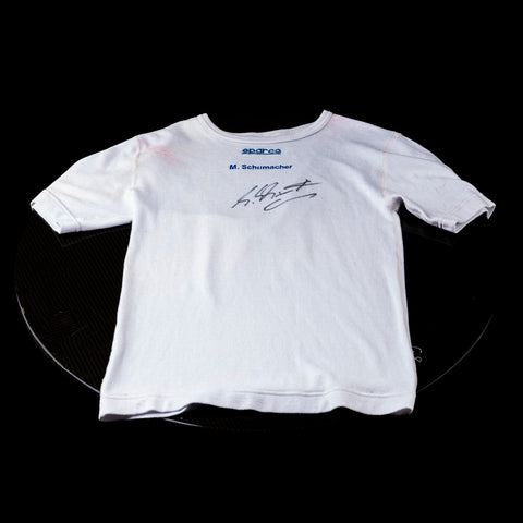 Michael Schumacher’s original signed Ferrari shirt, perfect for collectors. / Maglia Ferrari originale firmata da Schumacher, perfetta per collezionisti
